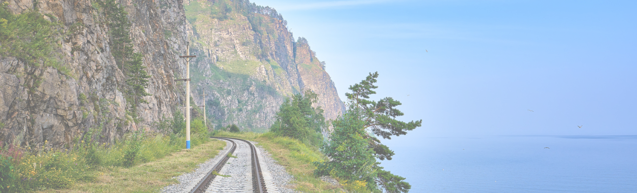 Single track railway line on edge of land between steep rock and Lake Baikal. Irkutsk region. Russia